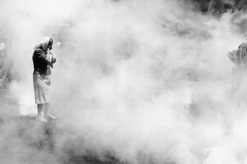 Eduardo Longoni. Una Madre de Plaza de Mayo queda paralizada, con una granada de gas lacrimógeno entre sus pies. Diciembre 2001.